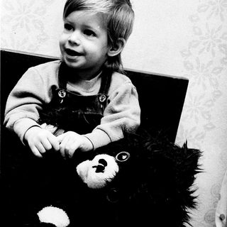 Young child holding a stuffed polar bear.