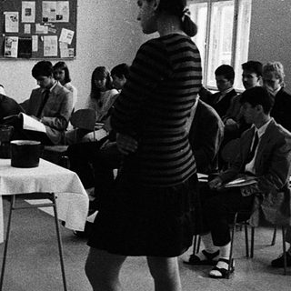 Classroom setting with instructor teaching seated students.