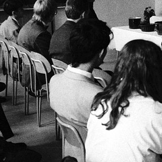 Formal meeting or conference with seated attendees and panelists.
