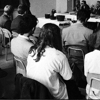 Formal meeting or conference with seated attendees and panelists.