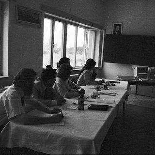 Classroom setting with students writing at desks.
