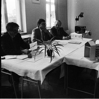 Business meeting with architectural models on table.