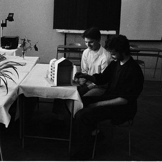 Four men in meeting discussing architectural model.