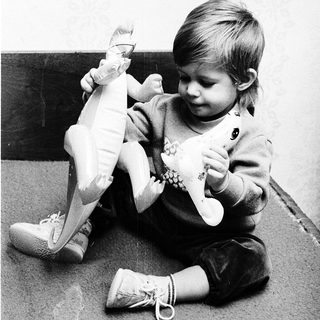 Child playing with large stuffed animal doll.