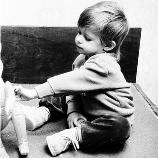 Young child playing with doll indoors.