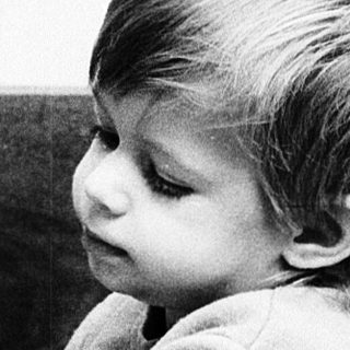 Young child playing with doll indoors.