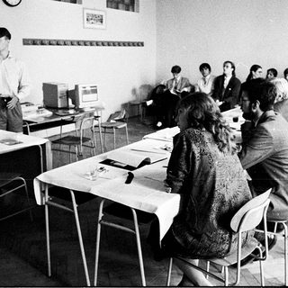 Classroom lecture with students using early computers.