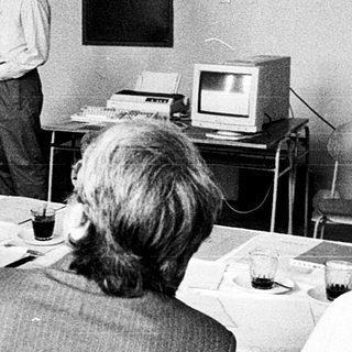 Classroom lecture with vintage computer demonstration.