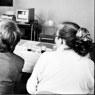 Classroom lecture with vintage computer demonstration.