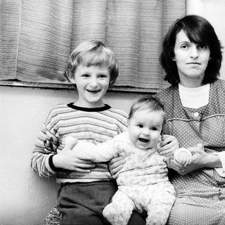 Family portrait with mother, toddler, and young boy.