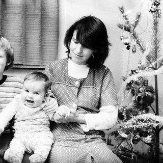 Family Christmas photo with mother, child, and baby.