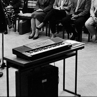 Formal conference or lecture with seated audience listening.