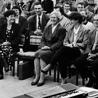 Formal conference or lecture with seated audience listening.