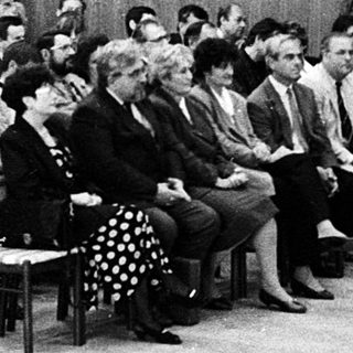 Formal meeting or conference with speaker addressing seated audience.