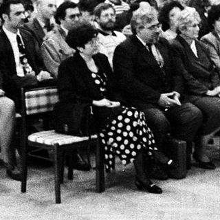Formal indoor lecture or meeting with speaker addressing audience.
