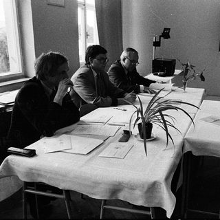 Four people engaged in a formal meeting or discussion.