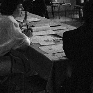 Classroom discussion or lecture with students seated at tables.