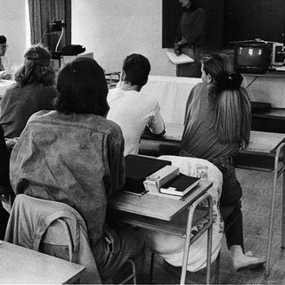 Classroom lecture with students seated at desks.