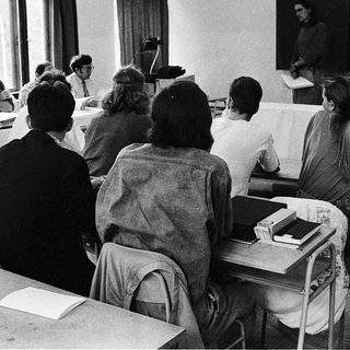 Classroom lecture with students seated at desks.