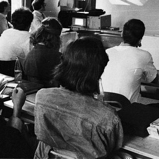 Classroom lecture with audience facing projector slide.