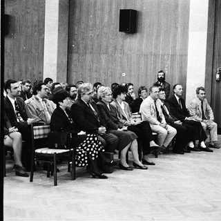 Formal indoor meeting or conference with speaker addressing audience.