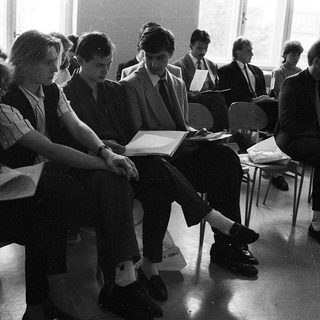 Students sitting in exam with open books.