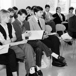 Group of students attending a formal lecture or meeting.