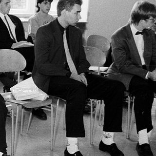 Group of students attending a formal lecture or meeting.