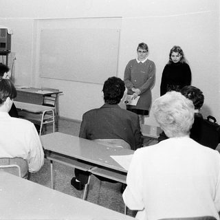 Classroom scene with teacher and students in 1970s-style schoolroom.