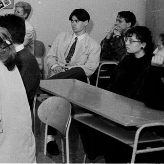 Classroom setting with teacher explaining to seated students.