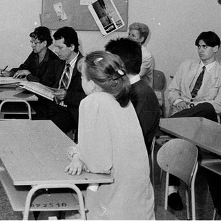 Classroom setting with teacher explaining to seated students.