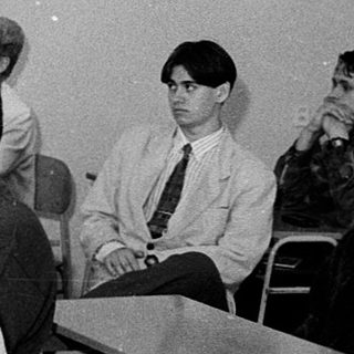 Classroom setting with teacher explaining to seated students.