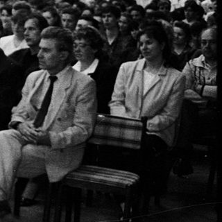 Concert or lecture hall with audience and performer.