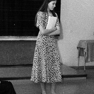 Classroom lecture with woman speaking at blackboard.