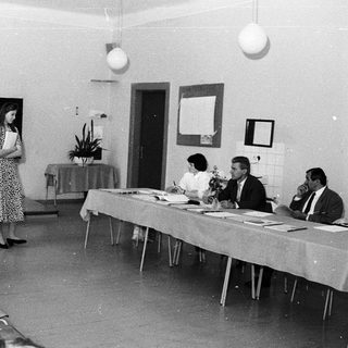 Classroom lecture with woman speaking at blackboard.