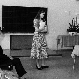 Classroom lecture with woman speaking at blackboard.