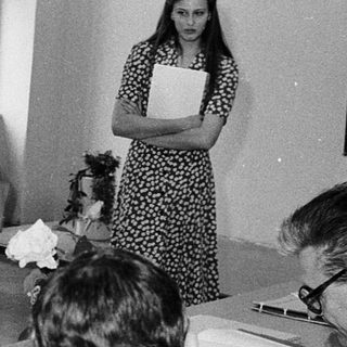 Classroom meeting with students and instructors discussing documents.