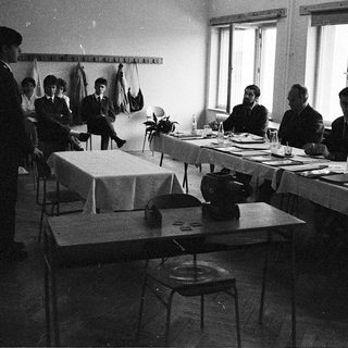 Classroom setting with students writing at desks during a typing lesson.