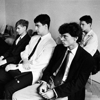 Group of young people sitting attentively in a formal setting.