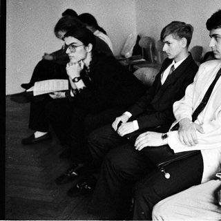 Group of young people sitting attentively in a formal setting.