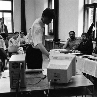 Early computer training session with instructor and students.