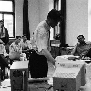 Early computer training session with instructor and students.