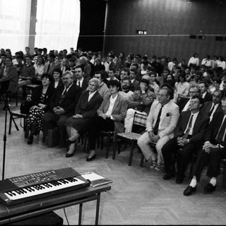 A formal lecture or conference with speaker and seated audience.