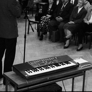 A formal lecture or conference with speaker and seated audience.