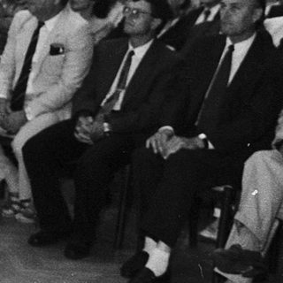 A speaker addresses an audience during a formal indoor event.