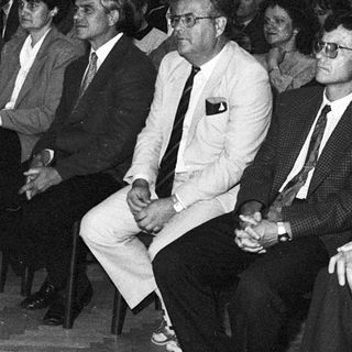 Formal gathering of men in suits attending an indoor event.