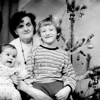 Family portrait with three generations near Christmas tree.