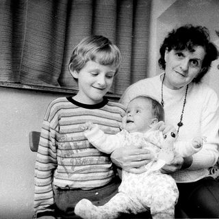 Family posing with Christmas tree and baby.
