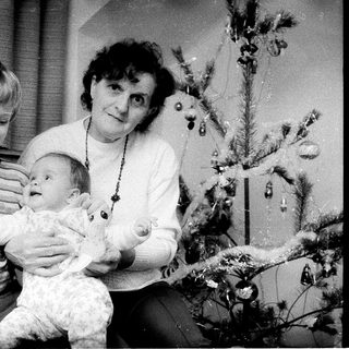 Family posing with Christmas tree and baby.