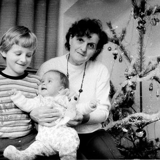 Family posing with Christmas tree and baby.